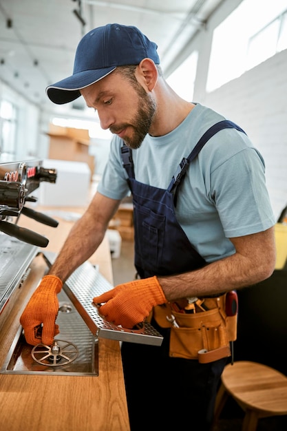 Reparador de la fijación de la máquina de café profesional en el café