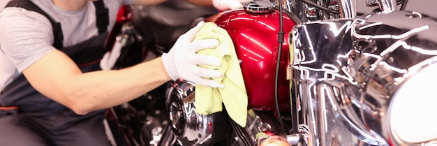 Reparador de hombre limpiando el tanque de la motocicleta con un trapo