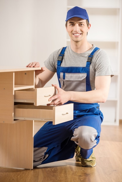 Reparador joven que ensambla el nuevo interior de la tabla en casa.