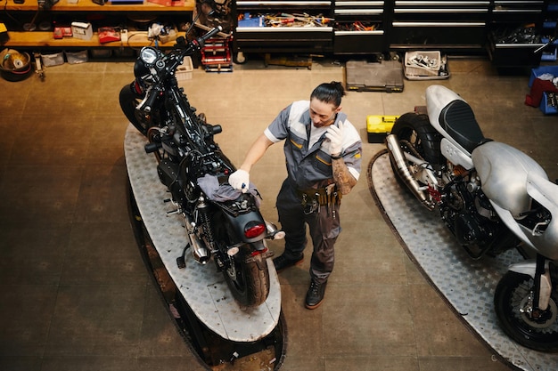 Foto el reparador llama al dueño de la motocicleta.