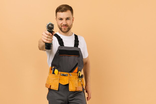 Reparador masculino positivo em casa com chave de fenda em fundo bege