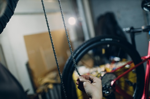 Reparador mecánico montando cadena de instalación de bicicletas personalizadas en el taller