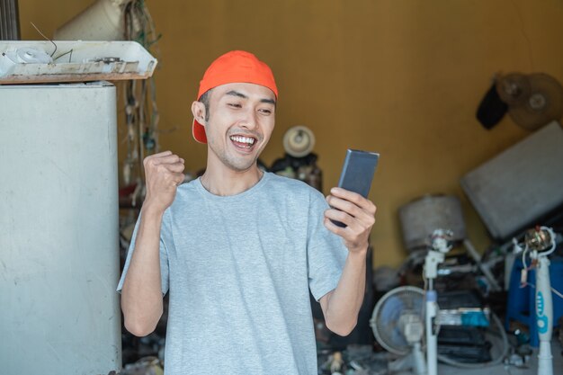 reparador olha para a tela do smartphone enquanto se posiciona em torno dos componentes eletrônicos