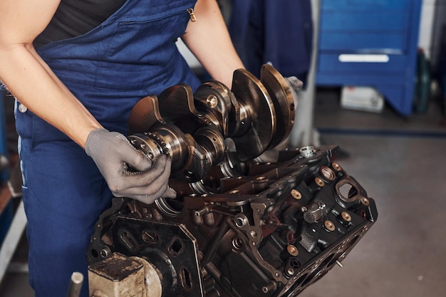 Reparador profesional en obras de garaje con motor de automóvil roto