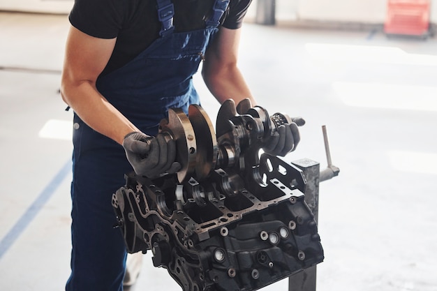 Reparador profesional trabaja con motor de automóvil roto