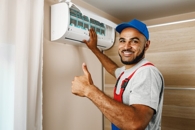 Reparador profissional instalando ar condicionado em uma sala