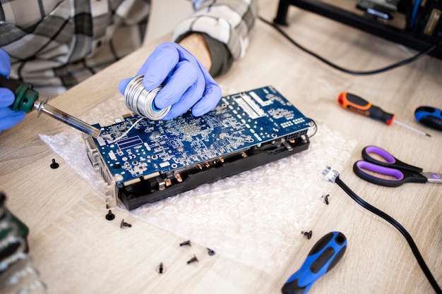 Reparador profissional reparando placa gráfica e placa de circuito impresso de solda