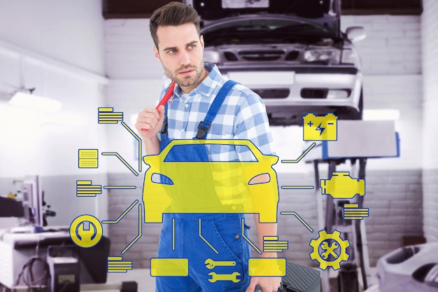 Foto reparador que lleva una caja de herramientas mientras mira hacia otro lado contra el taller de reparación de automóviles