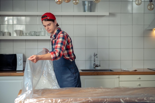 Reparador que protege la superficie de la mesa antes de los trabajos de reparación