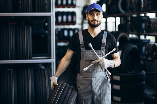 Reparador en el servicio de automóviles cambiando neumáticos