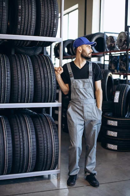 Reparador en el servicio de automóviles cambiando neumáticos