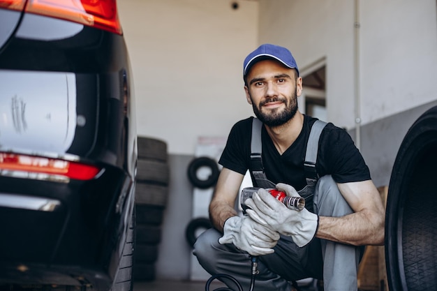 Reparador en el servicio de automóviles cambiando neumáticos