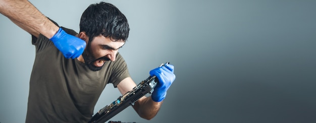 Reparador zangado com o computador na mesa