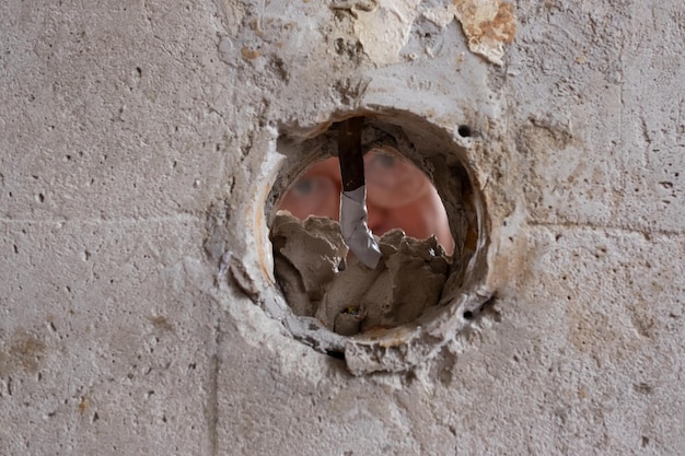 Reparando el hombre de la pared poniendo masilla en un agujero en la pared