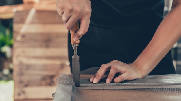 Reparar o caixilho da janela com uma nova tela de arame mosquiteiro. Fique em casa para reformar a casa. Estilo de vida durante a crise do vírus Corona. Bloqueio e auto-quarentena em casa.