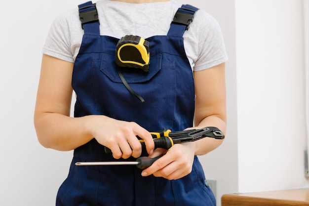 Reparar el radiador de calefacción mujer de primer plano reparar el radiador con una llave Quitar el aire del radiador