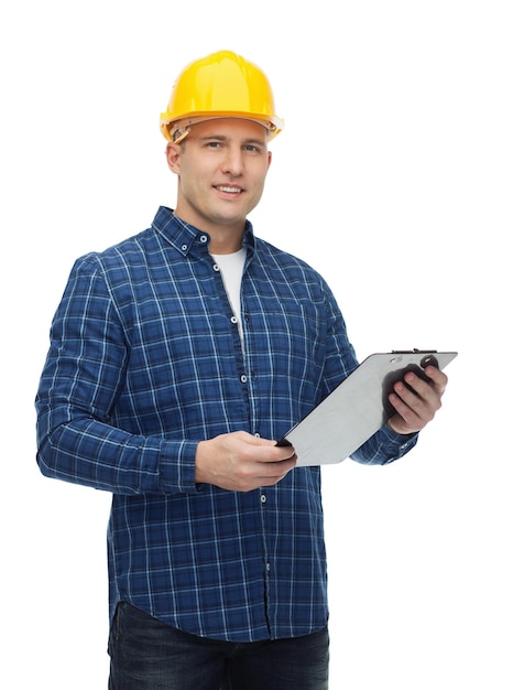 reparatur-, bau-, gebäude-, menschen- und wartungskonzept - lächelnder männlicher bauer oder arbeiter im helm mit klemmbrett