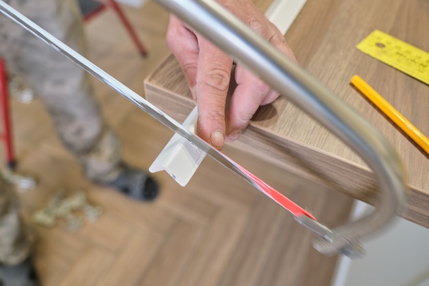 Reparatur im Haus, Installation und Schneiden von Holz gestrichenen Ecken