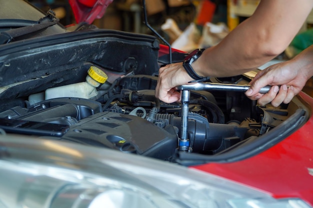 Reparatur von Automotor-Automobilfahrzeugteilen, die das Schrauben mit Werkzeugschlüsseln untersuchen, die in der Werkstattwerkstatt hart arbeiten