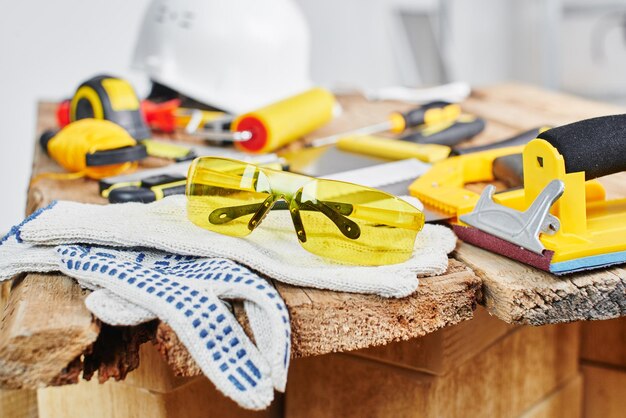 Reparaturen zu Hause. Bauwerkzeuge, Ziegel und Helm auf dem Holztisch