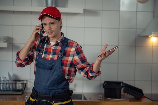 Foto reparaturtechniker im gespräch mit dem smartphone in der kundenwohnung