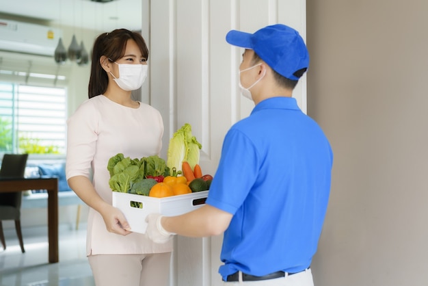 Repartidor asiático con caja de alimentos