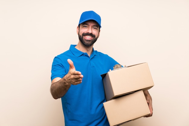 Repartidor con barba estrechándole la mano por cerrar un buen trato