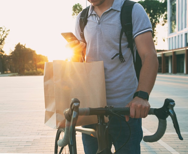 Repartidor en la bicicleta esperando que el cliente dé el pedido.