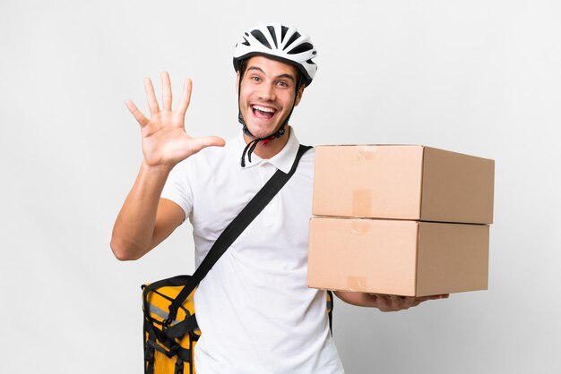 Repartidor con casco de bicicleta sobre fondo blanco aislado contando cinco con los dedos