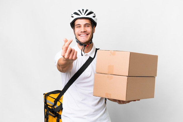 Repartidor con casco de bicicleta sobre fondo blanco aislado haciendo gesto de dinero