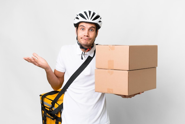 Repartidor con casco de bicicleta sobre fondo blanco aislado que tiene dudas mientras levanta las manos