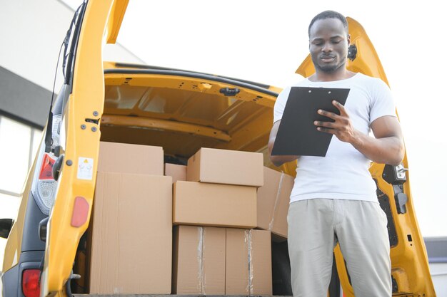 Repartidor cerca de minivan de envío