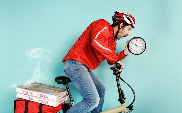 Repartidor corre rápido con bicicleta eléctrica para entregar pizza y evitar retrasos