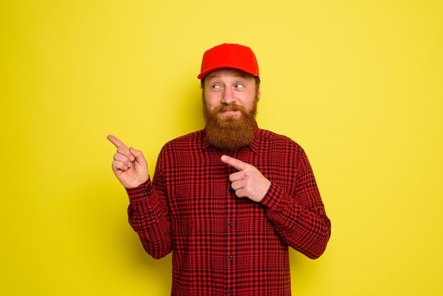 Repartidor feliz con sombrero y barba indica algo