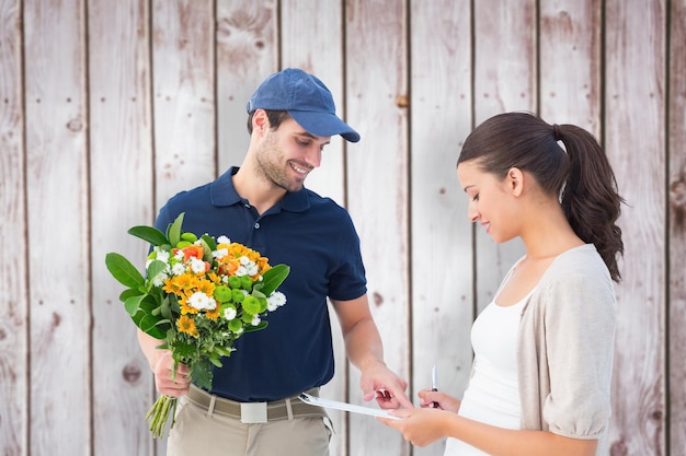 Foto repartidor de flores feliz con el cliente contra los tablones de madera