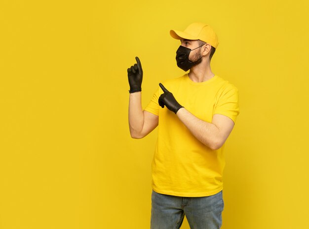 Repartidor con gorra amarilla, uniforme de camiseta, guantes de máscara aislados