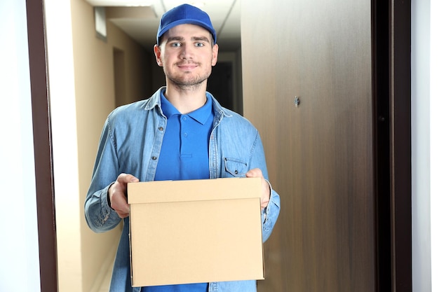 El repartidor con gorra azul tiene una caja en blanco