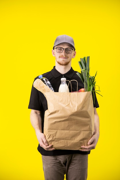 Repartidor guapo con bolsa de papel de comida