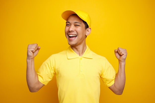 Repartidor joven emocionado con gorra y uniforme haciendo gesto de sí