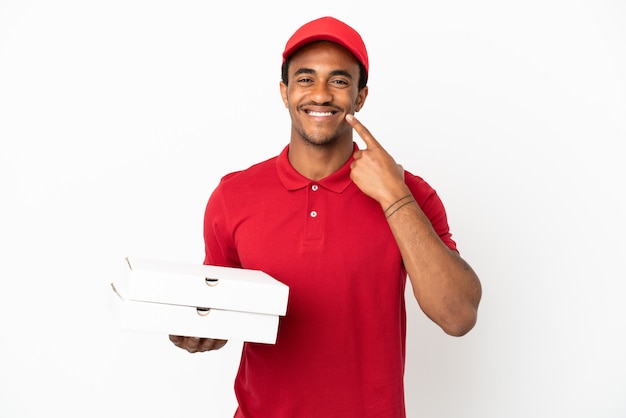 Repartidor de pizza afroamericana recogiendo cajas de pizza sobre pared blanca aislada dando un pulgar hacia arriba gesto