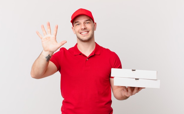 Repartidor de pizza a hombre sonriendo y mirando amigable, mostrando el número cinco o quinto con la mano hacia adelante, contando hacia atrás