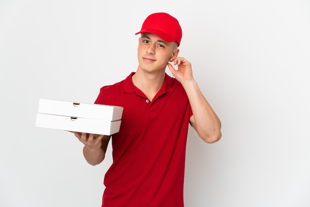 Repartidor de pizzas con uniforme de trabajo recogiendo cajas de pizza aisladas