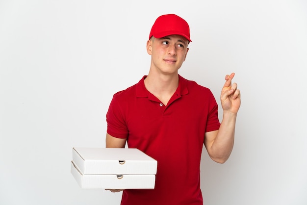 Repartidor de pizzas con uniforme de trabajo recogiendo cajas de pizza aislado sobre fondo blanco.