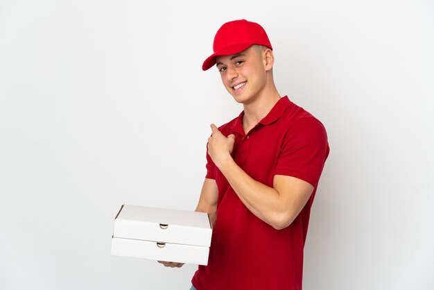 Repartidor de pizzas con uniforme de trabajo recogiendo cajas de pizza