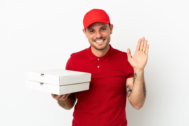 Repartidor de pizzas con uniforme de trabajo recogiendo cajas de pizza