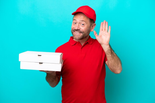 Repartidor de pizzas con uniforme de trabajo recogiendo cajas de pizza