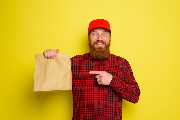 Repartidor con sombrero y barba tiene una expresión feliz