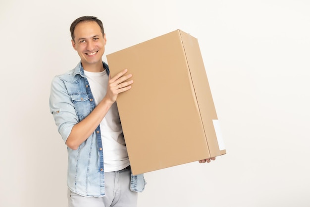 repartidor sonriente sosteniendo un paquete grande aislado en blanco