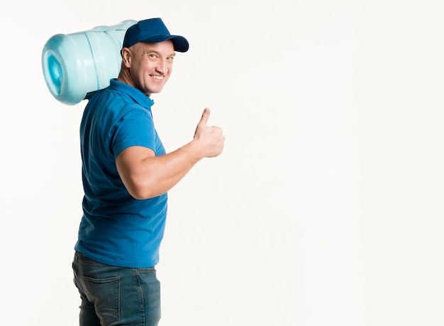 Repartidor sosteniendo la botella de agua y mostrando los pulgares para arriba