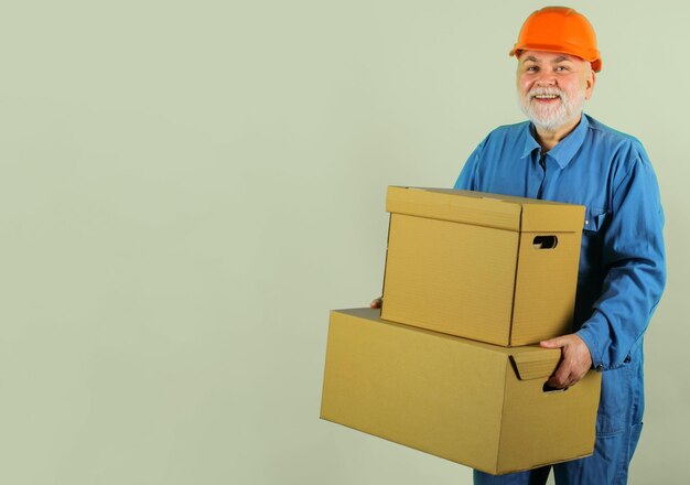 Repartidor en uniforme con cajas de cartón mensajero barbudo feliz con espacio de copia de caja de cartón